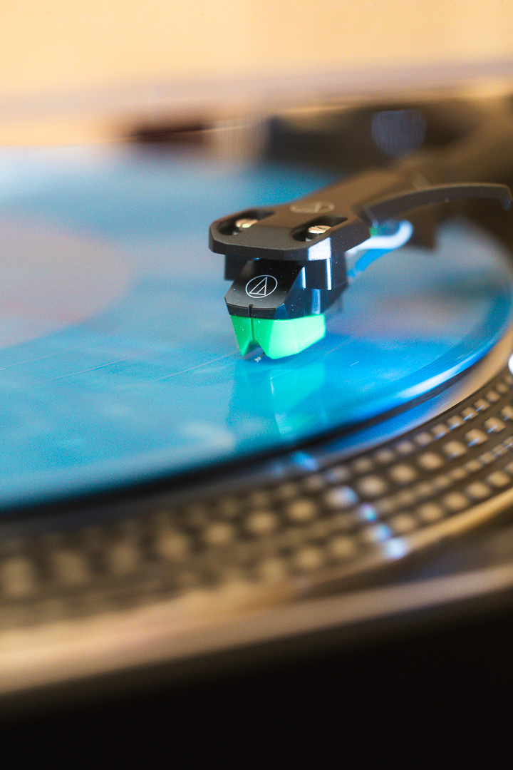 Gros plan sur une platine vinyle et un disque bleu